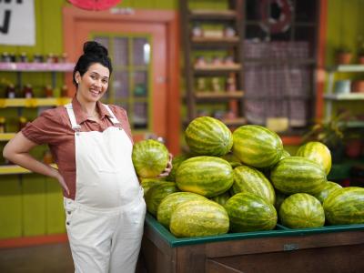 Woman holding a Watermelon while Pregnant